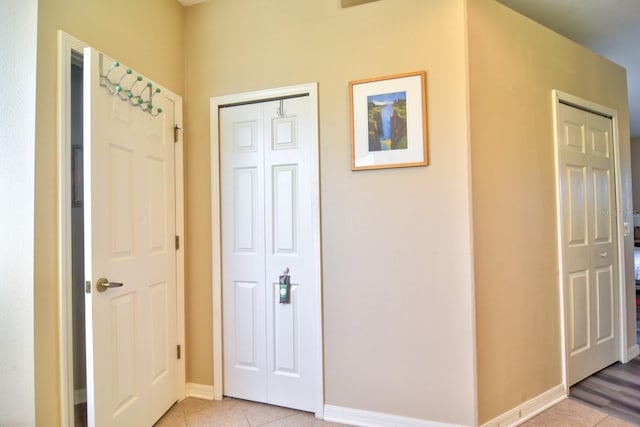 entryway featuring baseboards and light tile patterned flooring