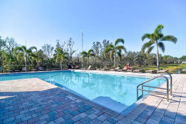 community pool with a patio and fence