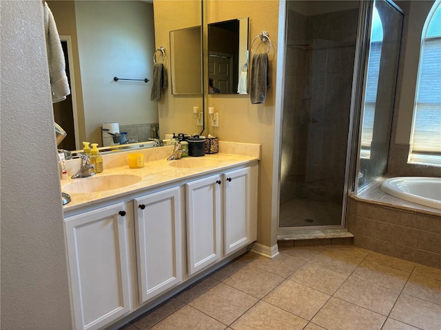 bathroom with double vanity, a sink, a bath, and tile patterned floors