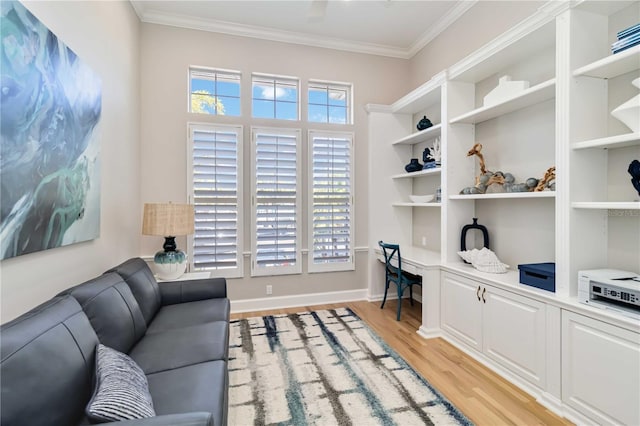 office featuring baseboards, light wood finished floors, built in study area, and crown molding