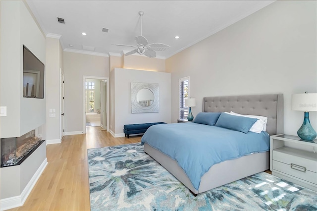 bedroom featuring ornamental molding, multiple windows, wood finished floors, and visible vents