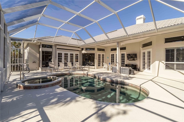 view of swimming pool with ceiling fan, a lanai, french doors, a patio area, and a pool with connected hot tub