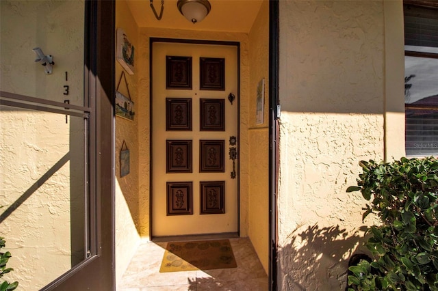 view of exterior entry with stucco siding