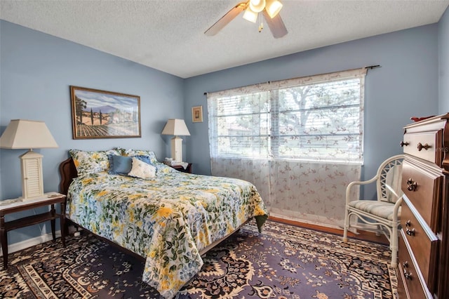 bedroom featuring ceiling fan, a textured ceiling, and baseboards