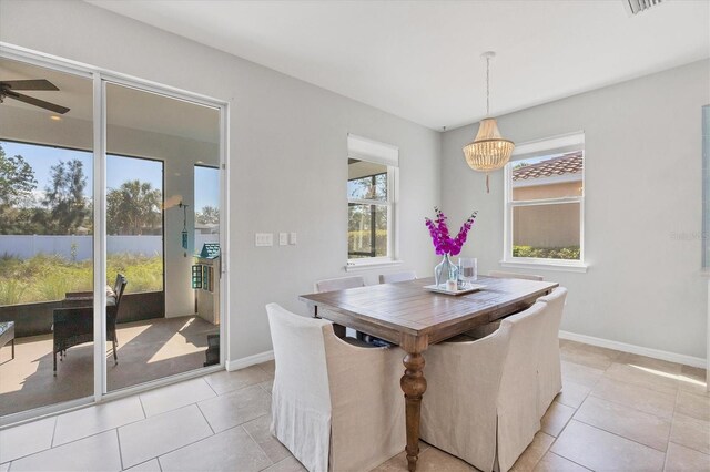 5333 Charlie Brown Ln, Sarasota, FL 34233 - dining area with a chandelier, light tile patterned floors, a ceiling fan, and baseboards