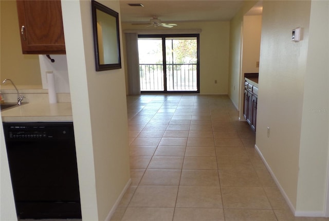 kitchen with baseboards, light tile patterned flooring, a sink, ceiling fan, and black dishwasher