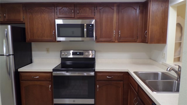 kitchen with stainless steel appliances, light countertops, and a sink