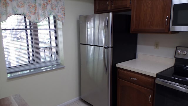 kitchen featuring appliances with stainless steel finishes, light countertops, and baseboards