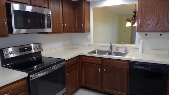 kitchen featuring light tile patterned floors, appliances with stainless steel finishes, light countertops, and a sink