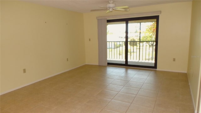 spare room with baseboards, ceiling fan, and light tile patterned flooring