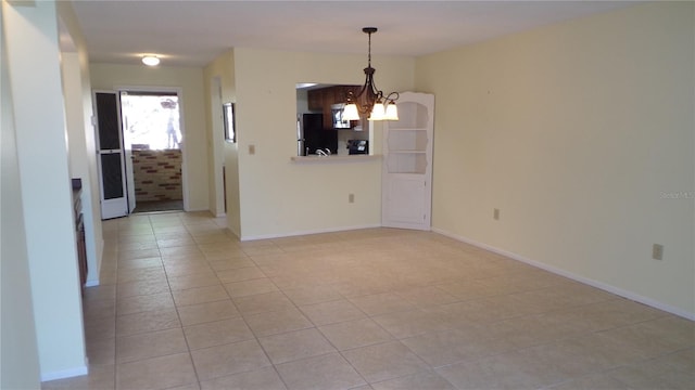 spare room with baseboards, a chandelier, and light tile patterned flooring