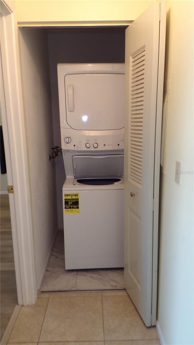 laundry area featuring laundry area, stacked washer and dryer, and baseboards