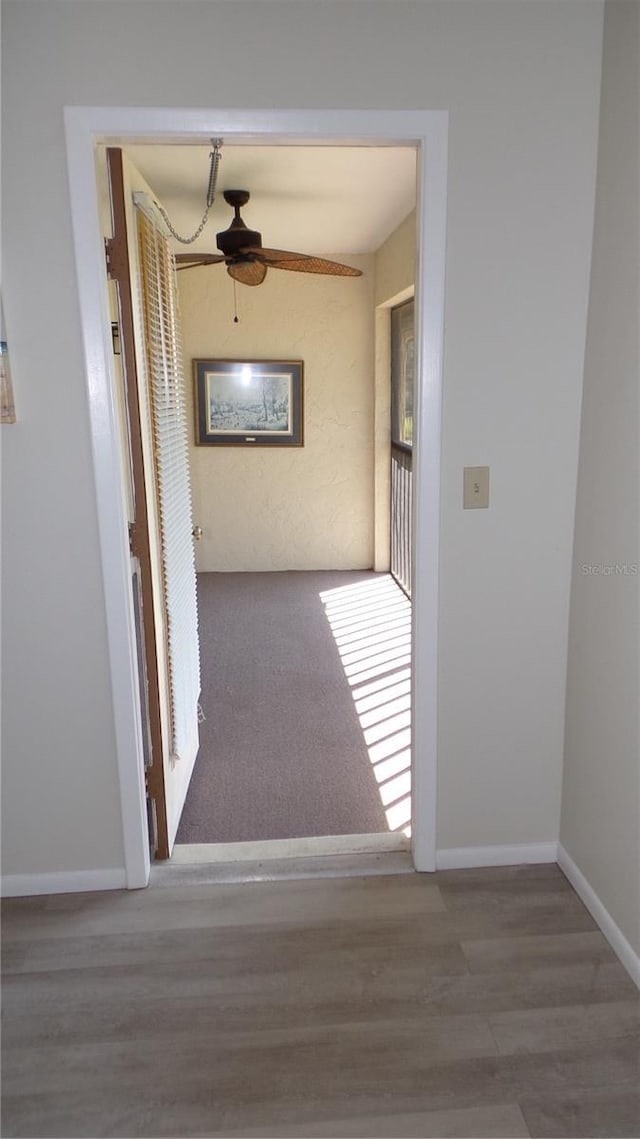 hall with wood finished floors and baseboards