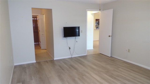 unfurnished bedroom featuring wood finished floors and baseboards