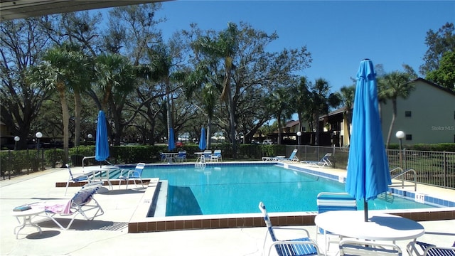 community pool featuring a patio area and fence