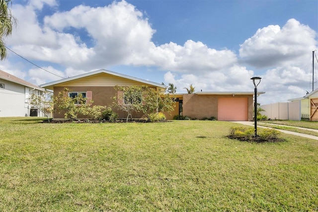 ranch-style home featuring driveway, a front lawn, an attached garage, and fence