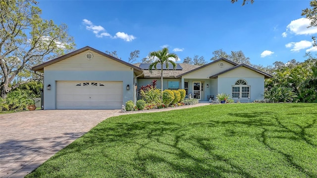 ranch-style house with a garage, solar panels, a front lawn, and decorative driveway