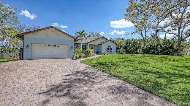 ranch-style home with a garage, decorative driveway, a front yard, and stucco siding