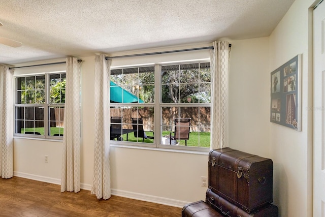 sitting room with a healthy amount of sunlight, baseboards, and wood finished floors