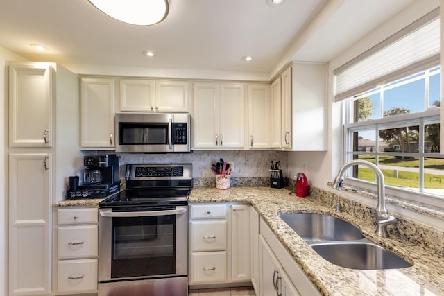 kitchen with white cabinetry, stainless steel appliances, a sink, and recessed lighting