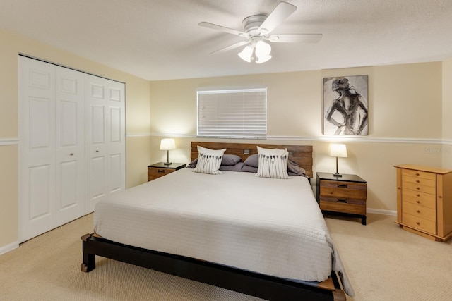 carpeted bedroom with a closet, ceiling fan, and baseboards