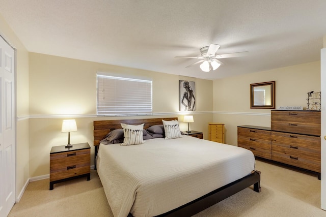 bedroom with light carpet, ceiling fan, and baseboards