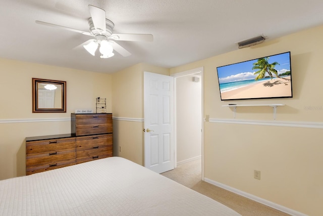 bedroom with light carpet, a ceiling fan, visible vents, and baseboards