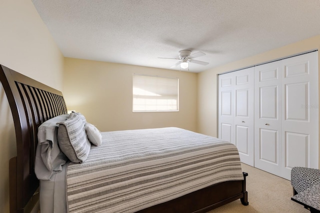 carpeted bedroom with a closet, ceiling fan, and a textured ceiling