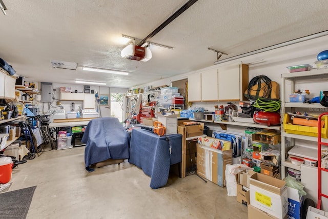 garage with electric panel, a workshop area, and a garage door opener