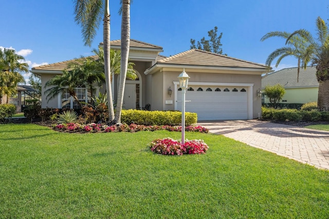 view of front of home with a garage, a front lawn, decorative driveway, and stucco siding