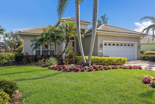 view of front of home featuring a garage, a tile roof, decorative driveway, stucco siding, and a front yard