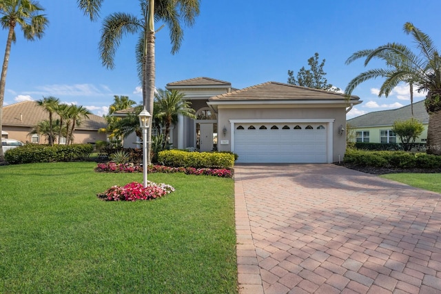 view of front facade with a garage, a front yard, decorative driveway, and stucco siding