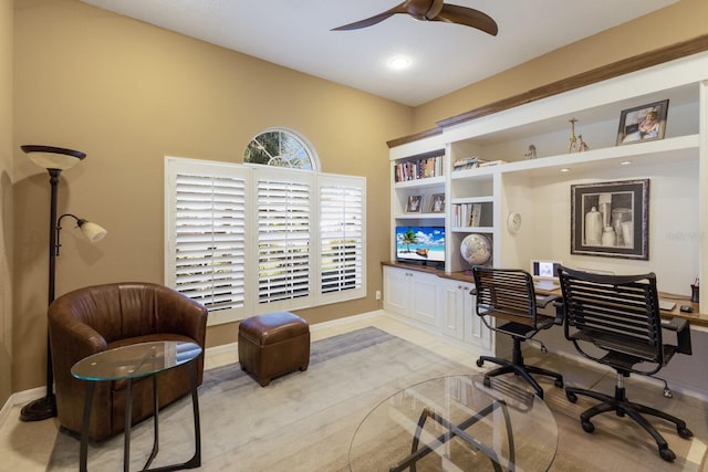 home office featuring light tile patterned floors, ceiling fan, and baseboards