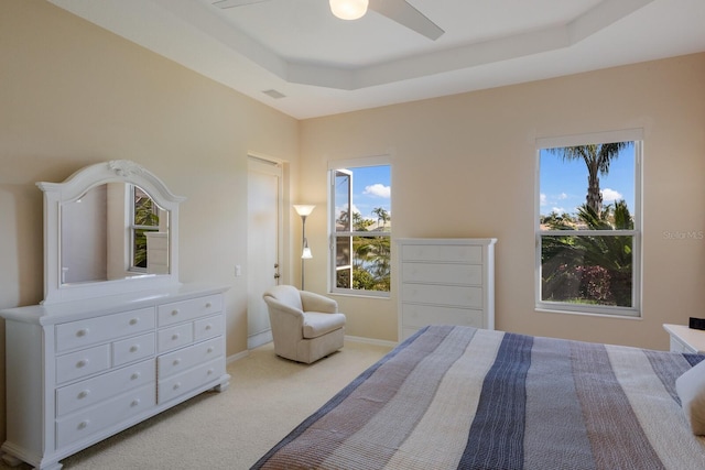 bedroom with visible vents, baseboards, ceiling fan, a tray ceiling, and carpet floors