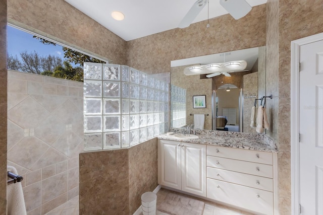 bathroom with ceiling fan, vanity, and a walk in shower