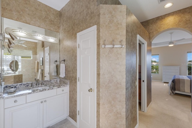 bathroom with baseboards, visible vents, a ceiling fan, ensuite bath, and vanity