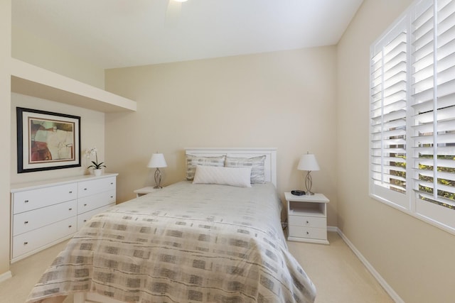 bedroom with light carpet and baseboards