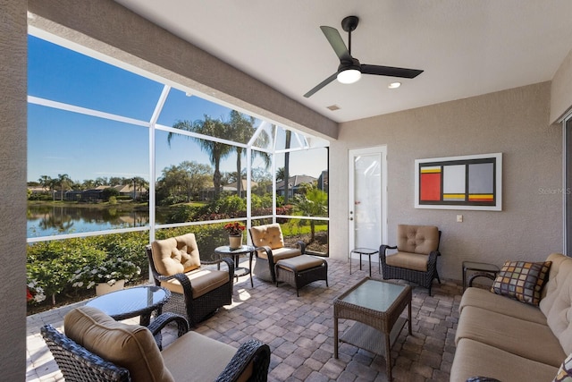 sunroom featuring a ceiling fan, a water view, and visible vents