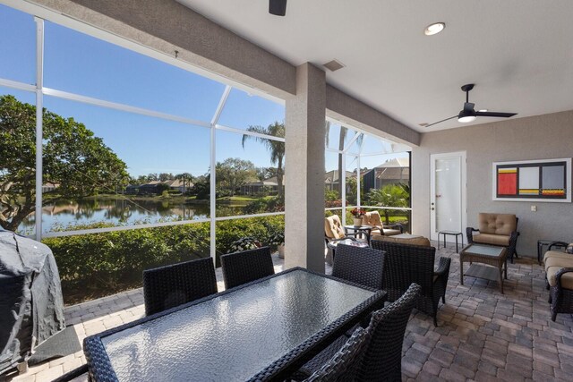 sunroom / solarium featuring a ceiling fan, a water view, and visible vents