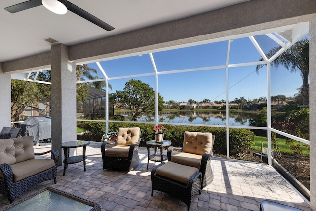 sunroom featuring a water view, ceiling fan, and visible vents