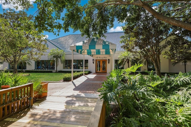 exterior space featuring a front yard, french doors, and stucco siding