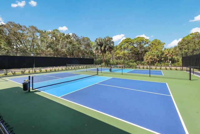 view of tennis court featuring community basketball court and fence