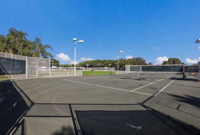 view of tennis court featuring fence