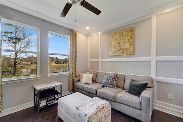 interior space featuring crown molding, dark wood finished floors, a water view, ceiling fan, and baseboards