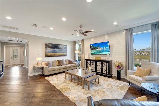 living area featuring arched walkways, plenty of natural light, visible vents, and recessed lighting