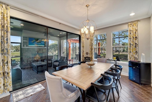 dining area featuring ornamental molding, recessed lighting, dark wood-style flooring, and a notable chandelier