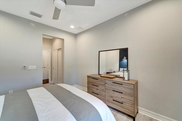 bedroom featuring a closet, visible vents, light wood-style flooring, a ceiling fan, and baseboards