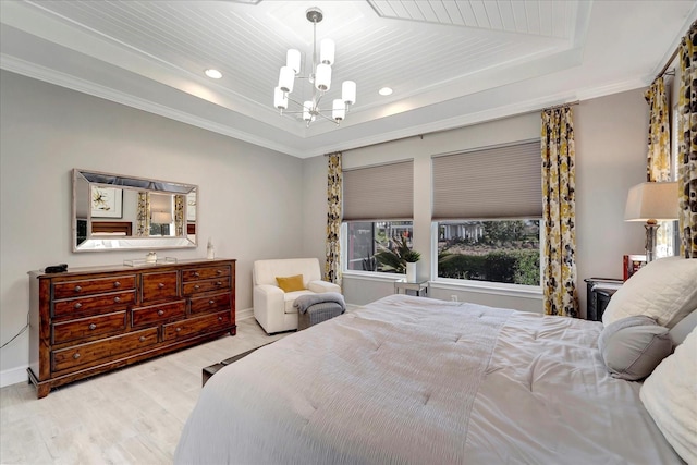 bedroom with ornamental molding, a tray ceiling, light wood-style flooring, and an inviting chandelier