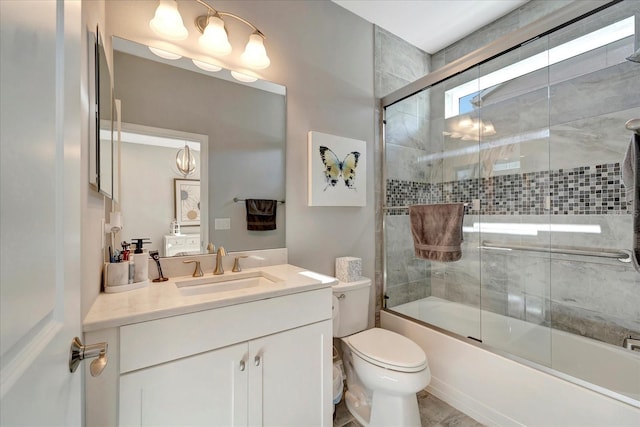 full bath with toilet, bath / shower combo with glass door, and vanity