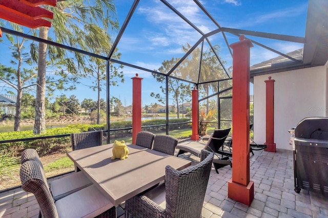 view of patio / terrace featuring glass enclosure, area for grilling, and outdoor dining space